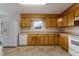 Galley kitchen with wood cabinets and appliances at 308 E First St, Princeton, NC 27569