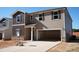 Two-story house with brown and beige siding, stone accents, and a two-car garage at 332 Squirrel Oaks Ln, Garner, NC 27529