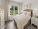 Bedroom with wicker headboard, beige bedding and window views at 356 Squirrel Oaks Ln, Garner, NC 27529