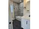 Modern bathroom boasts a white vanity, gray tiled tub/shower combo, and dark tile floors at 409 Granville St, Oxford, NC 27565