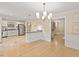 Open kitchen with a breakfast bar, modern appliances, and light wood cabinets at 4710 Tanglewood Dr, Raleigh, NC 27612