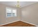 Simple bedroom with hardwood floors, neutral walls, and a chandelier at 502 Lemontree Ct, Graham, NC 27253