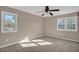 Spacious bedroom with neutral carpeting, ceiling fan, and large windows at 502 Lemontree Ct, Graham, NC 27253