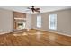 Living room with hardwood floors, a brick fireplace, and a ceiling fan at 502 Lemontree Ct, Graham, NC 27253