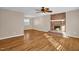 Spacious living room featuring hardwood floors, a brick fireplace, and a ceiling fan at 502 Lemontree Ct, Graham, NC 27253