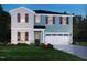 Two-story house with light blue siding, white accents, and a two-car garage at 524 Squirrel Oaks Ln, Garner, NC 27529