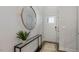 Bright entryway with a large circular mirror, console table, and a neutral color scheme at 714 Apple Churn Dr, Fuquay Varina, NC 27526