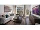 Living room features a white sofa, large window with backyard view, and a modern media console at 716 Apple Churn Dr, Fuquay Varina, NC 27526