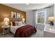 Cozy bedroom with maroon bedding and accent wall at 718 Apple Churn Dr, Fuquay Varina, NC 27526