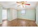 Light-filled bedroom with wood-look floors, ceiling fan, and access to outdoor space at 102 S 2Nd St, Micro, NC 27555