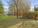 Spacious backyard with grassy area, wooden fence, and mature trees at 108 N Woodshed Ct, Cary, NC 27513