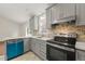 Modern kitchen with gray cabinets, stainless steel appliances, and tile backsplash at 108 N Woodshed Ct, Cary, NC 27513