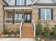 Brick home with front porch, steps, and landscaping at 184 Dereham Ln, Garner, NC 27529