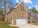 Brick house with a white two-car garage and landscaping at 184 Dereham Ln, Garner, NC 27529