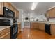 Open kitchen with black appliances and hardwood floors at 1925 Serenade Cir, Raleigh, NC 27610