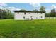 Large backyard with grassy lawn and white brick home at 2112 Eastwood Dr, Durham, NC 27703