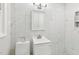 Clean bathroom with marble tile, vanity, and updated fixtures at 2112 Eastwood Dr, Durham, NC 27703