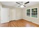 Well-lit bedroom featuring hardwood floors, ceiling fan, and two windows at 2112 Eastwood Dr, Durham, NC 27703