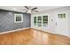 Living room with hardwood floors, gray geometric wall, and a ceiling fan at 2112 Eastwood Dr, Durham, NC 27703