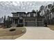 Two-story modern home with gray siding, three-car garage, and landscaped yard at 25 Gambel Dr, Youngsville, NC 27596