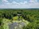 House surrounded by trees and pond at 3240 Hillcastle Trl, Chapel Hill, NC 27516
