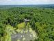 House nestled in a wooded area near a pond at 3240 Hillcastle Trl, Chapel Hill, NC 27516