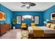 Blue bedroom with hardwood floors, ceiling fan, and mid-century modern furniture at 3240 Hillcastle Trl, Chapel Hill, NC 27516