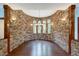 Stone-walled dining room with hardwood floors and arched windows at 3240 Hillcastle Trl, Chapel Hill, NC 27516