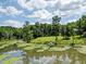 Red house sits on a pond's edge at 3240 Hillcastle Trl, Chapel Hill, NC 27516