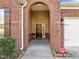 Covered front porch entryway with brick columns and a security system at 4148 White Kestrel Dr, Raleigh, NC 27616