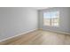 Well-lit bedroom featuring hardwood floors and a large window at 5230 Portside Ln, Raleigh, NC 27610