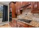 Kitchen boasts granite countertops, dark wood cabinets, and a tile backsplash at 5600 Thornburg Dr, Wake Forest, NC 27587