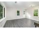 Spacious living room with gray vinyl plank flooring and multiple windows at 7100 Lake Myra Rd, Wendell, NC 27591