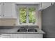 Kitchen with white cabinets, granite countertops, and a double sink with a view of the backyard at 148 Silver Lake Pt Pt, Sanford, NC 27332