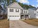 Two-story house with gray and white siding, stone accents, and a two-car garage at 1807 Nellora Ln, Durham, NC 27703