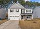 Two-story house with gray and white siding, stone accents, and a two-car garage at 1807 Nellora Ln, Durham, NC 27703