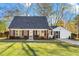 Brick ranch house with a white addition, landscaped lawn, and a driveway at 203 Hillside Dr, Smithfield, NC 27577