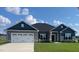 Gray and blue two-story house with a three-car garage and a landscaped lawn at 37 Streamline Ct, Lillington, NC 27546