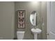 Simple and elegant powder room with pedestal sink and oval mirror at 110 Tobacco Woods Dr, Youngsville, NC 27596