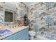 Powder room with light blue vanity, patterned wallpaper, and a toilet at 1816 Hunting Ridge Rd, Raleigh, NC 27615