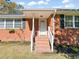 Brick ranch house with covered porch and a landscaped yard at 5813 Cheek Rd, Durham, NC 27704