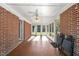 Spacious sunroom with tile floor, brick walls, and ceiling fan at 5813 Cheek Rd, Durham, NC 27704