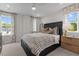 Comfortable bedroom with striped bedding, ceiling fan, and a large window at 622 Brittany Ct, Durham, NC 27703