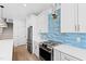 Modern kitchen with stainless steel range, white cabinets and blue tile backsplash at 65 Sir Oxford Ln, Angier, NC 27501