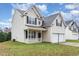 Two-story house with beige siding, a white garage door, and a well-maintained lawn at 2124 Star Sapphire Dr, Raleigh, NC 27610