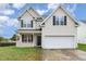 Two-story house with beige siding, a white garage door, and a well-maintained lawn at 2124 Star Sapphire Dr, Raleigh, NC 27610