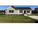 Newly built home with a beige exterior, landscaped lawn, and a paved driveway at 29 Pate Landing Dr, Selma, NC 27576