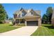 Two-story house with brick and siding, a large driveway, and landscaping at 407 Eagle Ct, Henderson, NC 27536