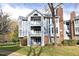 Gray and brick condo building with balconies and yard at 1081 Wirewood Dr # 302, Raleigh, NC 27605