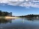 Peaceful lakefront view of the community clubhouse and sandy beach at 109 Lone Star Dr, Louisburg, NC 27549